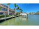 Beautiful waterfront home with a private boat lift and dock on a sunny day at 975 Whitakers Ln, Sarasota, FL 34236