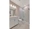 Bathroom featuring a white vanity, toilet, and glass enclosed shower with marble-style walls at 10394 Abaco Falls Dr, Englewood, FL 34223
