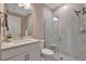 Modern bathroom featuring marble-style walls, a glass shower, and white vanity at 10394 Abaco Falls Dr, Englewood, FL 34223