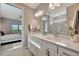 Bright bathroom featuring a marble shower, dual vanity and quartz countertop with bedroom view at 10394 Abaco Falls Dr, Englewood, FL 34223