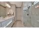 Bright bathroom featuring a marble shower, dual vanity and quartz countertop at 10394 Abaco Falls Dr, Englewood, FL 34223