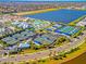 Aerial view of the community amenities with tennis courts, pool, and clubhouse near a large lake at 10394 Abaco Falls Dr, Englewood, FL 34223