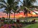 Scenic view of the community featuring a lake, palm trees, and a vibrant sunset at 10394 Abaco Falls Dr, Englewood, FL 34223
