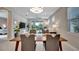 Dining room with a wooden table and seating for four, overlooking the living room and outdoor patio at 10394 Abaco Falls Dr, Englewood, FL 34223