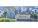 Inviting community entrance with striking tower feature, lush landscaping, and eye-catching Beachwalk signage at 10394 Abaco Falls Dr, Englewood, FL 34223