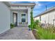 Inviting front porch featuring a seating area and manicured landscaping with climbing vines at 10394 Abaco Falls Dr, Englewood, FL 34223