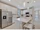 White kitchen featuring stainless steel appliances, an island with seating, and pendant lights at 10394 Abaco Falls Dr, Englewood, FL 34223