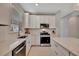 Bright kitchen with stainless steel appliances, including a range, and white cabinetry offering ample storage at 10394 Abaco Falls Dr, Englewood, FL 34223
