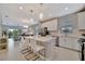Open-concept kitchen featuring a center island with bar seating and seamless flow into the living area at 10394 Abaco Falls Dr, Englewood, FL 34223