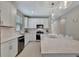 White kitchen featuring stainless steel appliances, an island with seating, and pendant lights at 10394 Abaco Falls Dr, Englewood, FL 34223