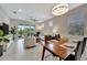 Bright living room and dining area featuring neutral tones, modern decor, and sliding glass doors to the backyard at 10394 Abaco Falls Dr, Englewood, FL 34223