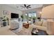 Comfortable living room with stylish furniture, a ceiling fan, and scenic views from the sliding doors at 10394 Abaco Falls Dr, Englewood, FL 34223
