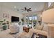 Inviting living room with large windows, neutral tones, and a ceiling fan for optimal comfort at 10394 Abaco Falls Dr, Englewood, FL 34223