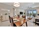 Open-concept living space with dining area, sliding glass doors to screened-in patio, and a glimpse of the bedroom at 10394 Abaco Falls Dr, Englewood, FL 34223