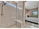 Shower with marble tile, window, and a built-in seat in bath with bedroom view at 10394 Abaco Falls Dr, Englewood, FL 34223
