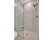 Frameless glass shower featuring white marble-style walls and tile flooring at 10394 Abaco Falls Dr, Englewood, FL 34223