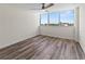 A simple bedroom with wood flooring and a large window at 1055 Beach Rd # B302, Sarasota, FL 34242