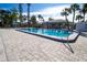 Community pool with lounge chairs, tables, and tropical landscaping at 1055 Beach Rd # B302, Sarasota, FL 34242