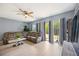 Spacious living area features a ceiling fan, neutral paint, tile flooring, and sliding glass doors to the backyard at 1122 42Nd E Ter, Bradenton, FL 34208