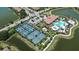 An aerial view features a community center with tennis courts, swimming pool, parking lot, and ponds surrounding the area at 12409 Osorio Ct # 102, Sarasota, FL 34238
