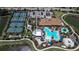 An aerial view showcases a community center with large swimming pool and spa, parking, and tennis courts in a residential area at 12409 Osorio Ct # 102, Sarasota, FL 34238