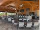 Covered outdoor bar featuring TVs, counter seating and casual table seating with ceiling fans at 12409 Osorio Ct # 102, Sarasota, FL 34238