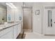 Well-lit bathroom featuring double sinks, a glass-enclosed shower, and modern finishes at 12409 Osorio Ct # 102, Sarasota, FL 34238