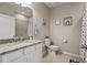 Bright bathroom featuring a granite countertop, neutral tile, and polka-dot shower curtain at 12409 Osorio Ct # 102, Sarasota, FL 34238