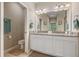 Bathroom featuring double sinks with granite countertops, ample cabinet space, and modern fixtures at 12409 Osorio Ct # 102, Sarasota, FL 34238