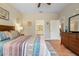 Cozy bedroom featuring warm wood floors, a comfortable bed, and a view to the bathroom at 12409 Osorio Ct # 102, Sarasota, FL 34238