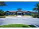 Beautiful clubhouse featuring tile roofing, stone accents, manicured landscaping and palm trees in a Florida community at 12409 Osorio Ct # 102, Sarasota, FL 34238