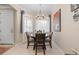 Well-lit dining room with a round table, four chairs, and bay windows with blue curtains at 12409 Osorio Ct # 102, Sarasota, FL 34238