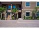 Beautiful condo exterior displaying the front doors, stone detail, and lush landscaping around the property at 12409 Osorio Ct # 102, Sarasota, FL 34238