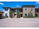 Stunning two-story condo showcasing lush landscaping, two-car parking, and a stylish facade under a clear blue sky at 12409 Osorio Ct # 102, Sarasota, FL 34238