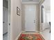 Inviting foyer with neutral walls, decorative rug and white door creating a welcoming entrance to the home at 12409 Osorio Ct # 102, Sarasota, FL 34238