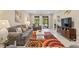 Bright living room features a stylish rug, comfortable seating, and sliding doors for indoor-outdoor flow at 12409 Osorio Ct # 102, Sarasota, FL 34238