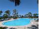 Large outdoor pool featuring lounge chairs, umbrellas, and lush landscaping for a resort-style experience at 12409 Osorio Ct # 102, Sarasota, FL 34238