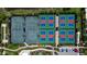An aerial view features outdoor tennis courts with red and blue surfaces, and a parking lot lined with palm trees at 12409 Osorio Ct # 102, Sarasota, FL 34238