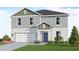 Charming two-story home with a gray-green exterior, a two-car garage, and freshly landscaped front yard at 13016 Cedar Elm Lane, Parrish, FL 34219