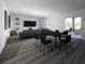 Open-concept living and dining area with hardwood floors, modern furniture, and access to outdoor patio at 13016 Cedar Elm Lane, Parrish, FL 34219