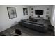 Modern living room featuring a gray sectional sofa, contemporary decor, and sleek, dark hardwood flooring at 13016 Cedar Elm Lane, Parrish, FL 34219