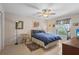 Neutral bedroom with a ceiling fan, tile floors, and a window overlooking the yard at 1308 Willow Oak Cir, Bradenton, FL 34209