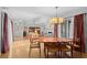 Open dining area with hardwood floors, a modern chandelier, and seamless flow into the living room at 1308 Willow Oak Cir, Bradenton, FL 34209