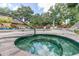 Community hot tub and pool area with lounge chairs and mature trees, perfect for relaxing on a hot day at 1308 Willow Oak Cir, Bradenton, FL 34209