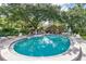 Beautiful community swimming pool with ample seating, mature landscaping, and clear blue water for relaxation at 1308 Willow Oak Cir, Bradenton, FL 34209