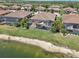 Aerial view of homes featuring screened-in pools, offering a serene lakeside setting and appealing outdoor living space at 13587 Vancanza Dr, Venice, FL 34293