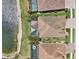 Top down aerial view of rear of lakefront homes with pools, landscaping and brick driveways at 13587 Vancanza Dr, Venice, FL 34293