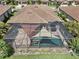 Aerial view showcasing a screened pool enclosure and lush landscaping at 13587 Vancanza Dr, Venice, FL 34293