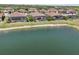 Aerial view showcases homes with screened-in pools lining a picturesque lake, creating a serene and upscale community setting at 13587 Vancanza Dr, Venice, FL 34293
