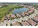 Aerial view of lovely homes with red tile roofs surrounding a large lake in a well-planned community setting at 13587 Vancanza Dr, Venice, FL 34293